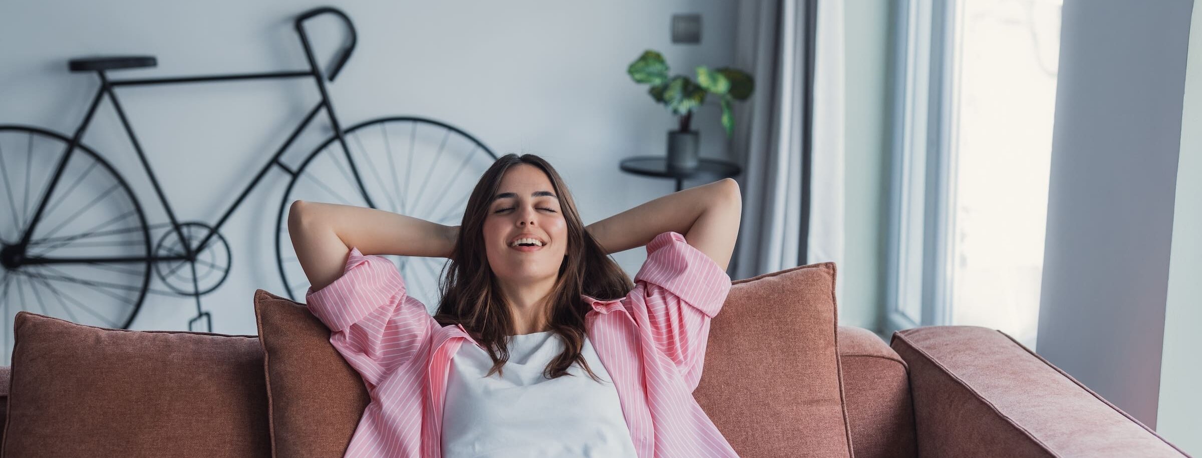 Woman relaxed on the couch, breathing in the air from her healthy house